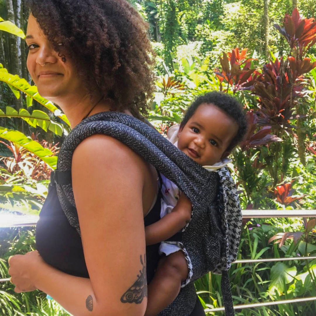 smiling-meghan-with-daughter-oya-in-carrier-on-back-with-botanical-garden-in-background