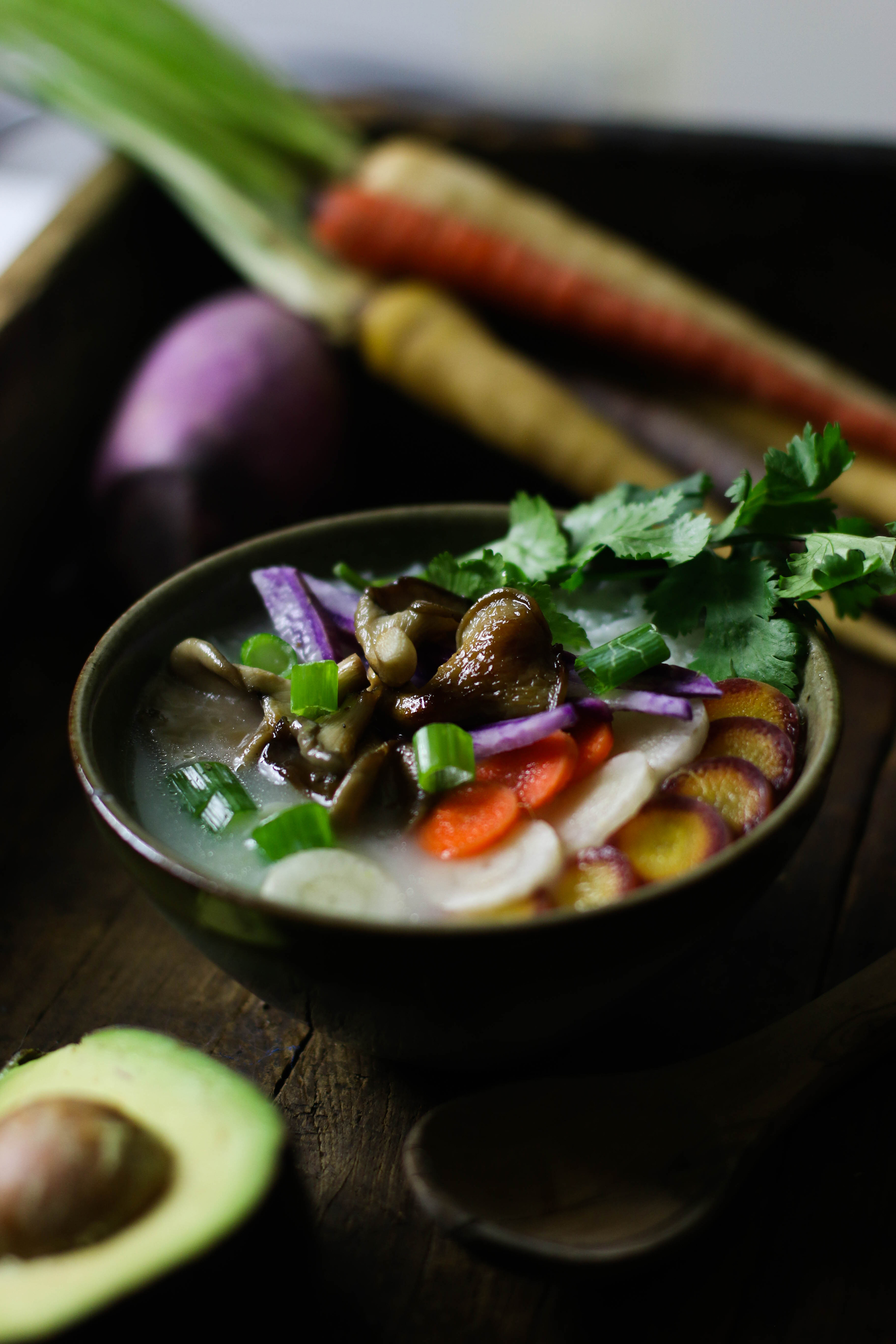 bowl-of-congee-rice-porridge-with-mushrooms-and-fresh-vegetables-with-carrots-in-background