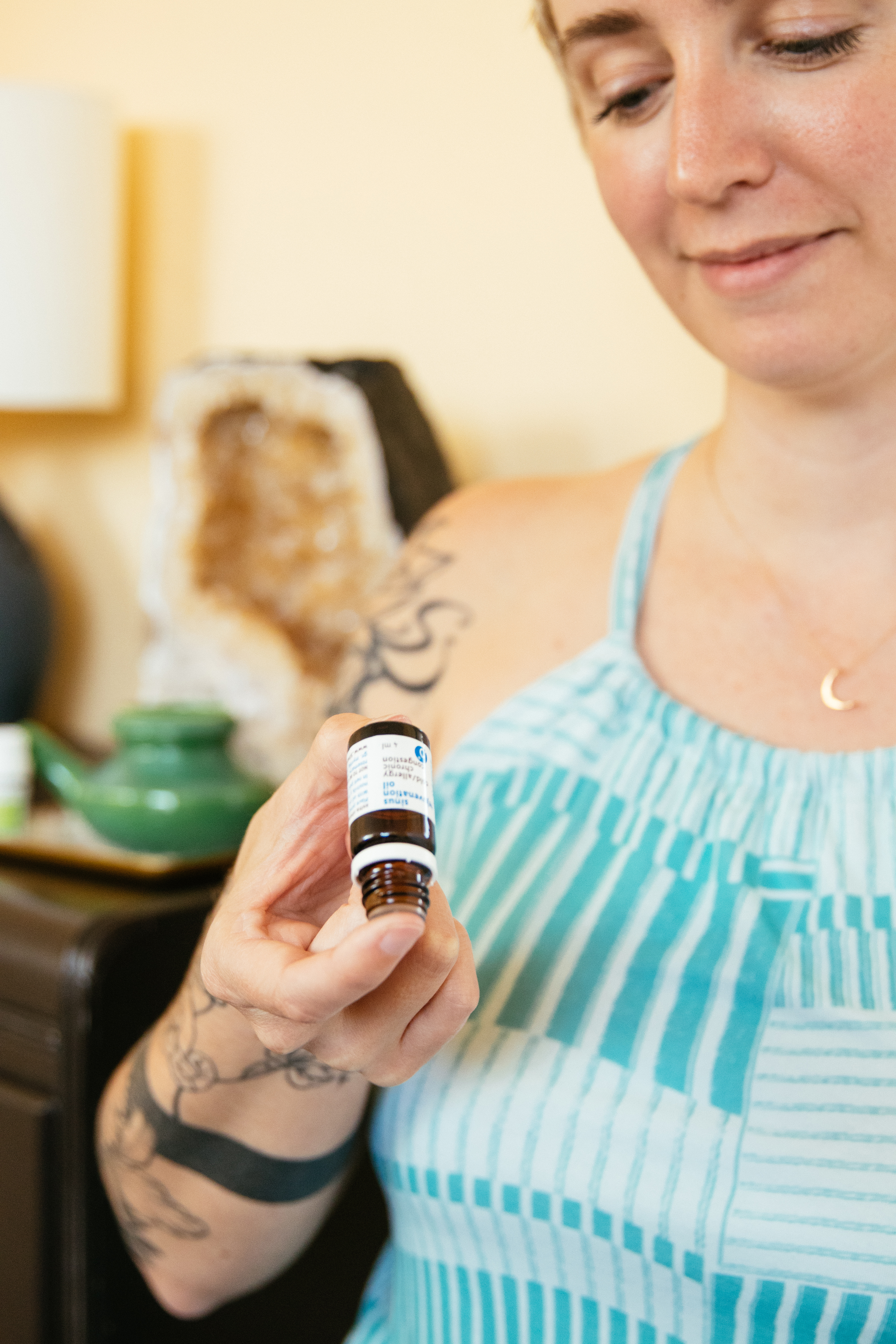 young-woman-with-tattoos-applying-sinus-essential-oil-to-fingertip