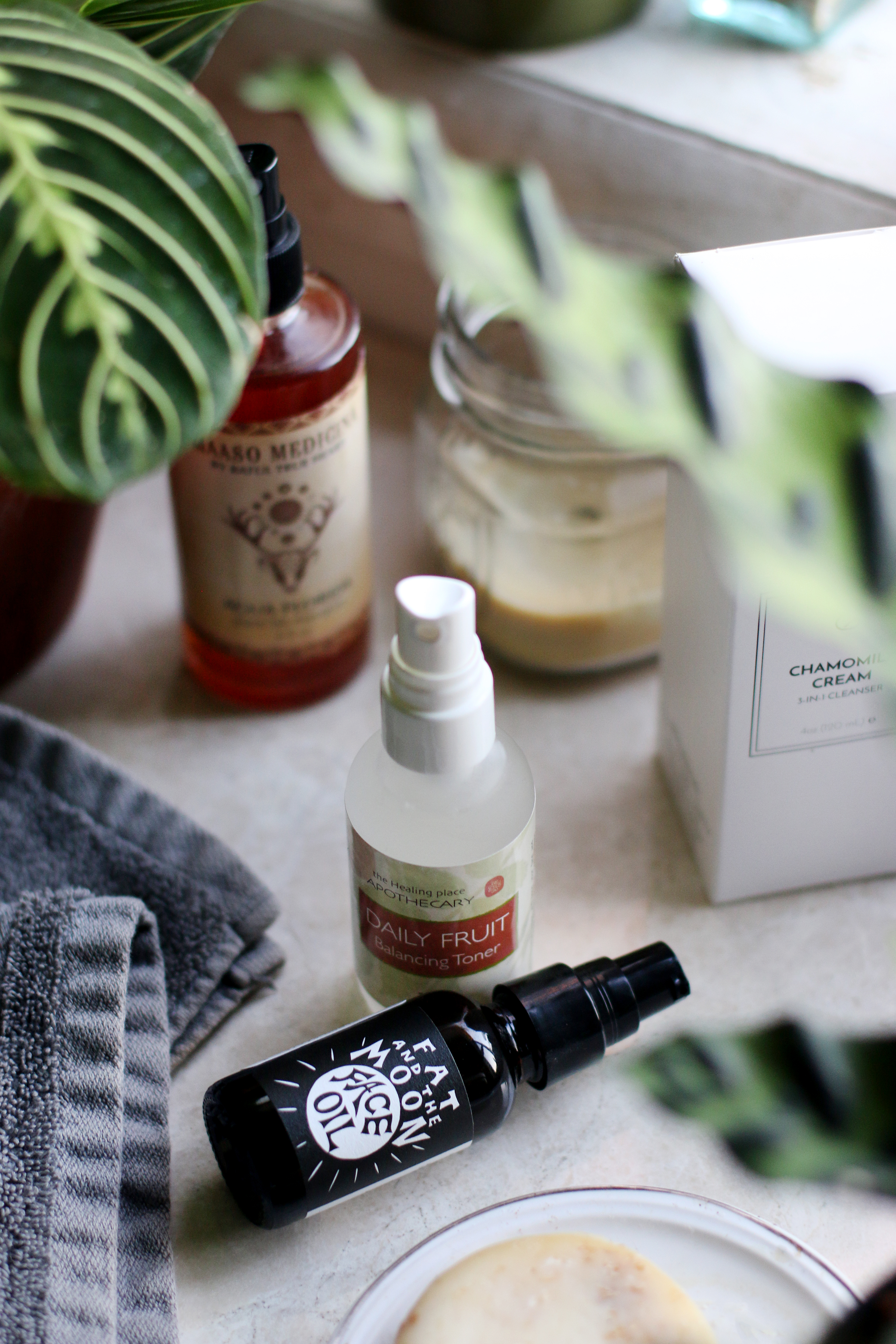 Bottles of natural face care products arranged on table with bath and body care items.