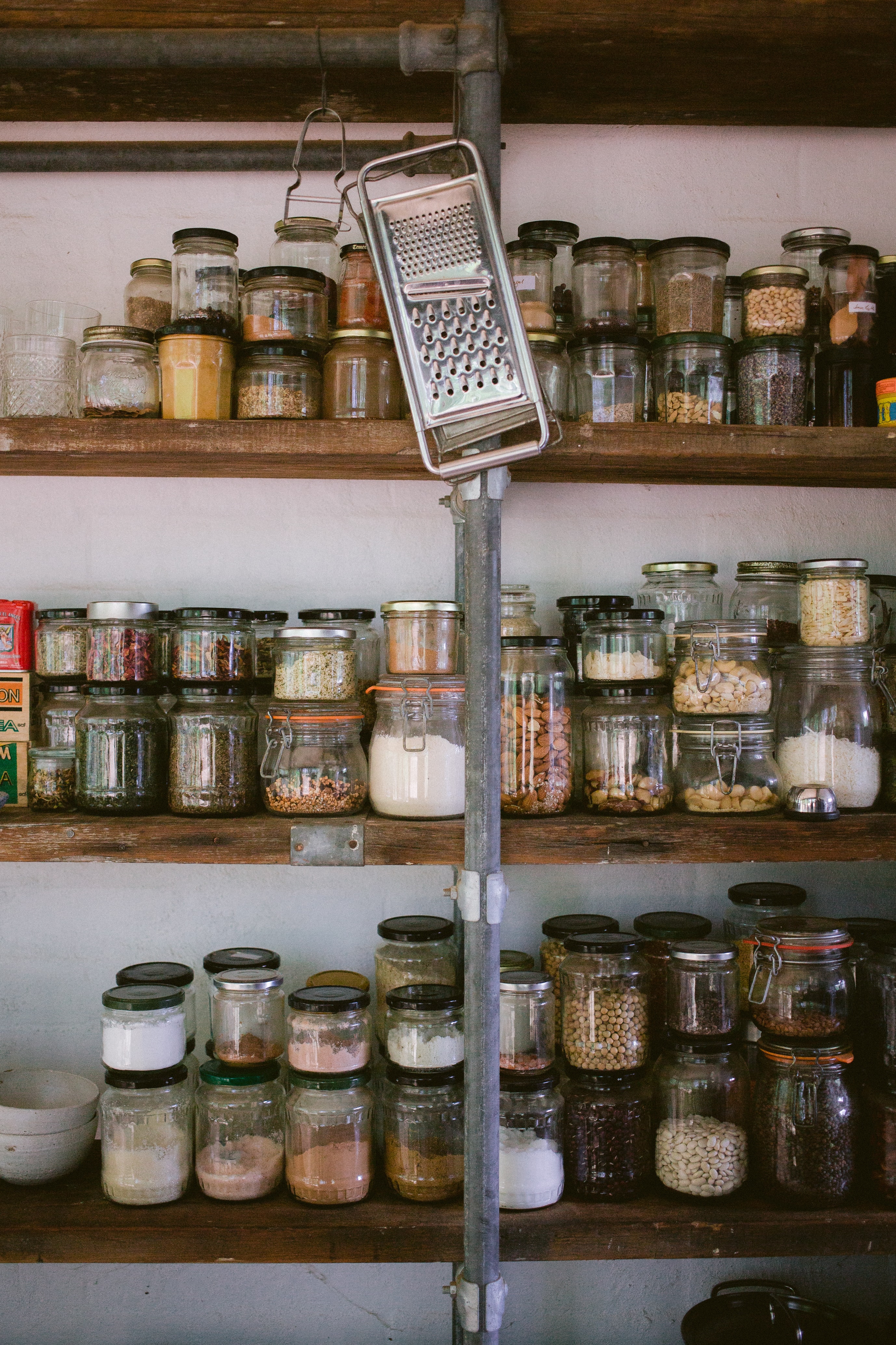 Wooden pantry shelves full of glass jars