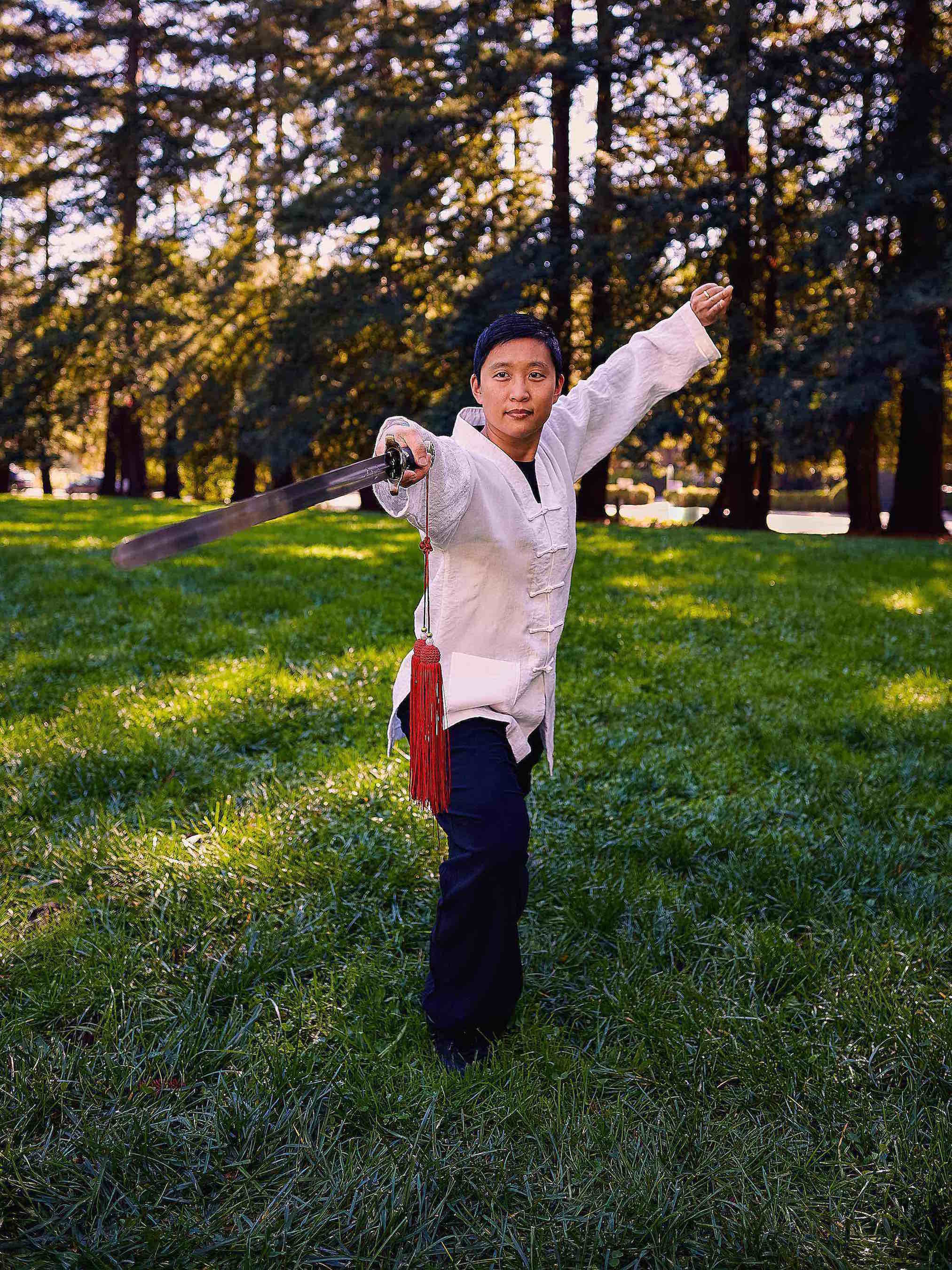 martial-artist-sally-chang-holding-gongfu-pose-with-sword-in-park-outdoors