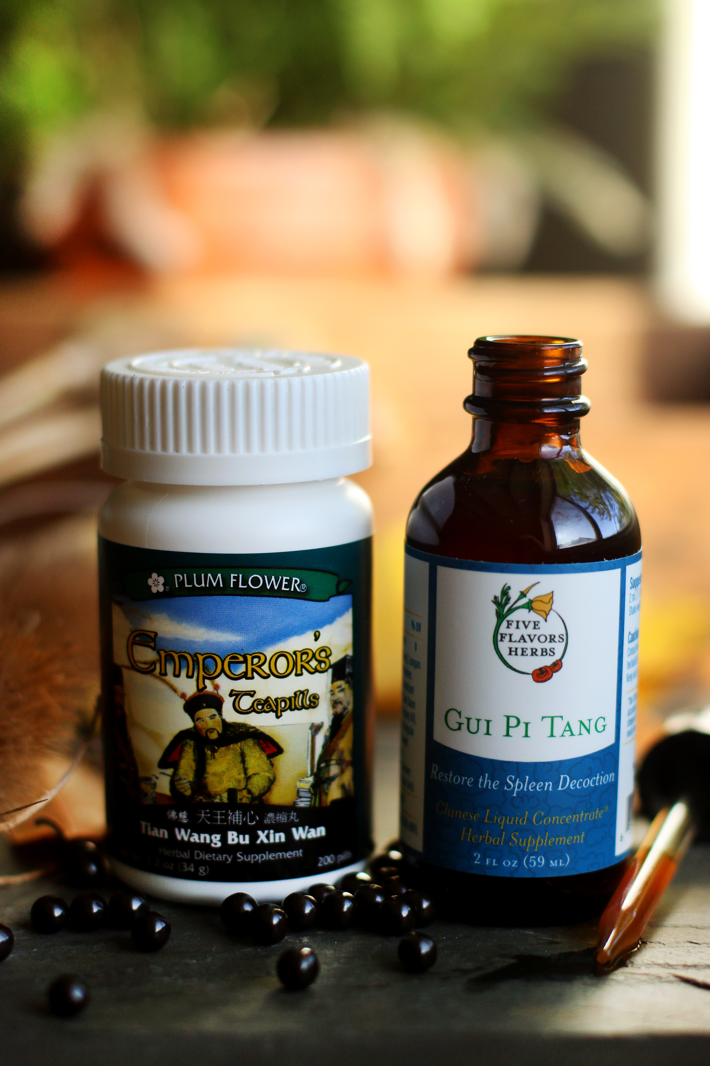 Bottle of Emperor's Tea pills next to bottle of Gui Pi Tang TCM extract with Panex ginseng tincture from Five Flavors Herbs.